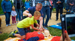 Rodzice wraz z dziećmi uczą się udzielania pierwszej pomocy